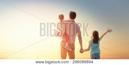 Happy loving family. Father and his daughters children playing and hugging outdoors. Cute little girls and daddy. 