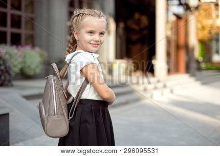 Happy Smiling Girl Is Going To School For The First Time With Bag Go To Elementary School. Pupil Go 