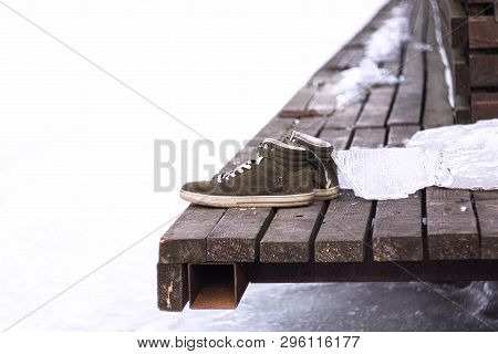 Mens Shoes On The Edge Of A Dock At The Frozen River