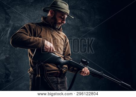 Opening Of The Spring Hunting Season. A Man Cleans Rifle Barrel, Maintenance Before Hunting.
