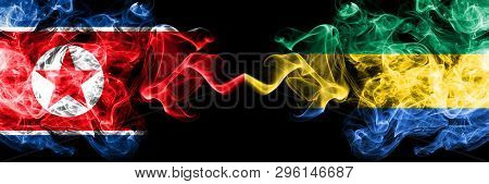 North Korea Vs Gabon, Gabonese Smoky Mystic Flags Placed Side By Side. Thick Colored Silky Smoke Fla