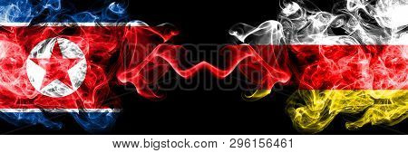 North Korea Vs South Ossetia Smoky Mystic Flags Placed Side By Side. Thick Colored Silky Smoke Flags