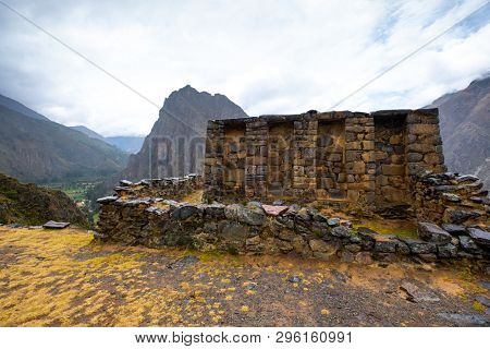 Stony walls with construction on Ollantaytambo mountanious landscape background