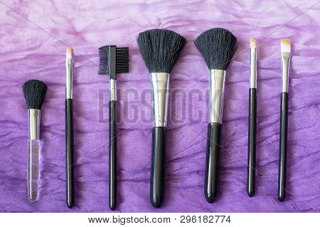 Professional Make-up Cosmetic Brushes On The Background Of Crumpled Wavy Fabric. The Concept Of Beau