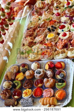Abundant Buffet With Trays Filled With Sweet Pastries And Filled Sandwiches