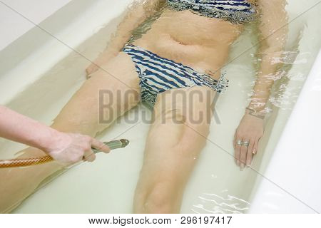Woman In Bath During Hydromassage In Beauty Spa Salon. Underwater Hydrotherapy Massage Procedure