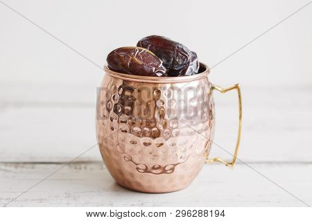 Dried Dates In A Big Metal Mug On Wooden Table. Traditional Arabic Dessert During Ramadan Month