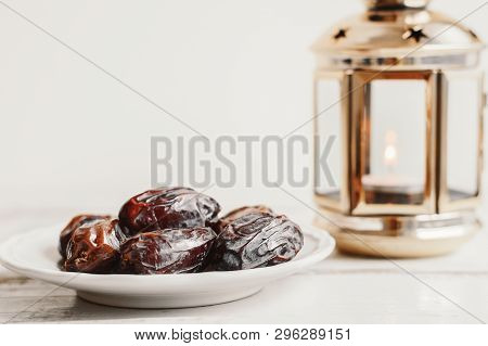 Dried Dates On White Plates And Lantern With Candle On Wooden Table. Ramadan Concept