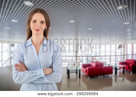 Beautiful Young Business Woman With Crossed Arms On Dealer Center Background
