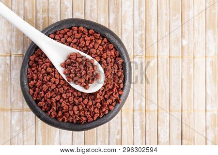 Annatto Seeds On Rustic Wood