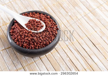 Annatto Seeds On Rustic Wood