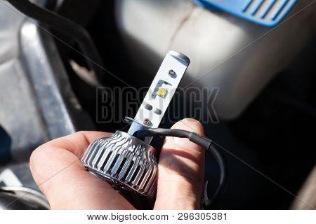 Man Hand Installing H7 Led Headlight Bulb With Wires. Modern Car Lighting Technology.