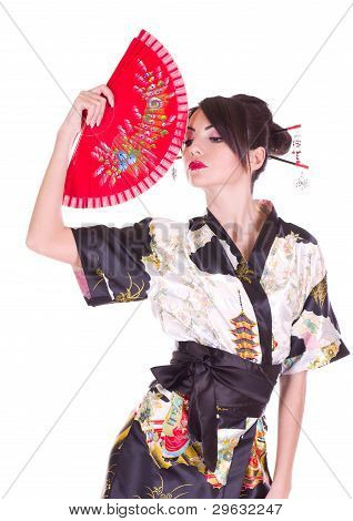 Beautiful young woman in Asian costume with red Asian fan