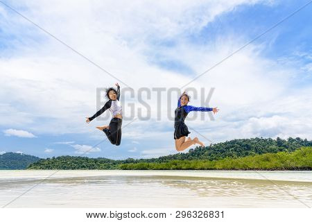 Happy Two Asian Teen Girls Friends Jumping Enjoy On The Beach Of Ko Ra Wi On Blue Sky Background Dur