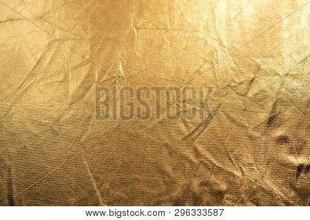 Gold refelecter fabric background with folds and wrinkles.  