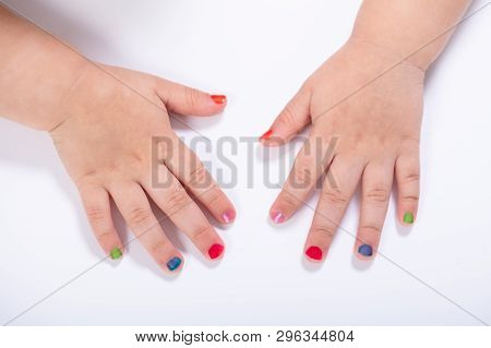 Close-up Small Girl Showing Colorful Nail Polish Against White Background