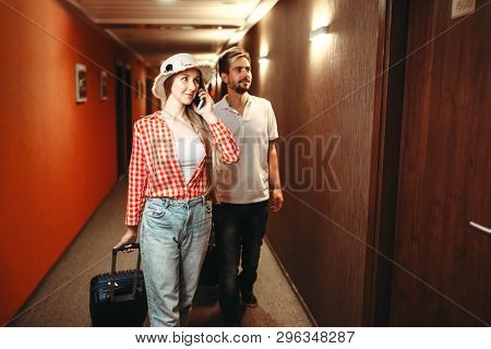 Couple with suitcases looking for their hotel room
