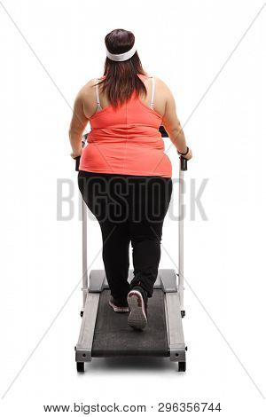 Full length rear view of a corpulent woman on a treadmill isolated on white background