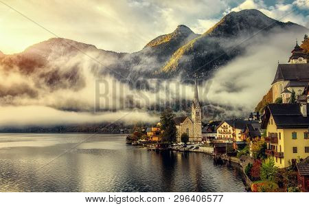 Impressive Athmospheric Scene. View On Hallstatt Lutheran Church, With Morning Fog Under Sunlit At S
