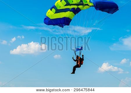 Male Skydiver Flies Under The Wing Of The Parachute, Descending And Coming In To Land Closer To The 