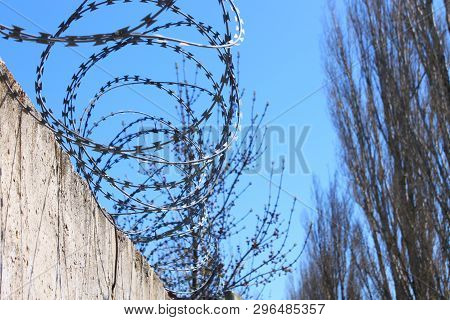 Barbed Wire On Fence With Blue Sky, The Concept Of Prison, Salvation, Copy Space.