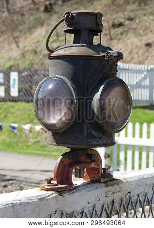 Old Metal And Glass Railway Lamp On Gate In Daylight