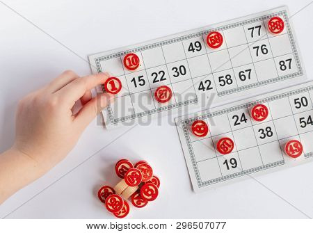 Bingo Or Lotto Game. Wooden Kegs Of Lotto On Cards. Cards And Chips For Playing Bingo On A White Tab
