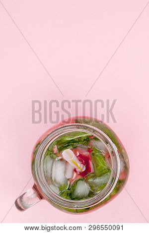 Jar Of Cold Fresh Lemonade With Piece Of Watermelon And Ice On Pink Background