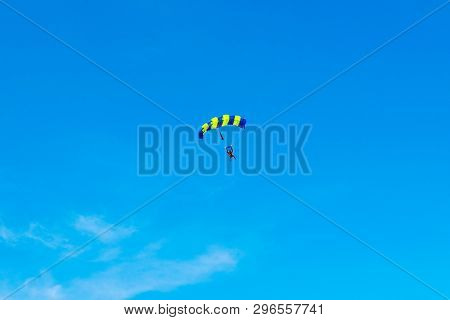 Male Skydiver Flies Under The Wing Of The Parachute, Descending And Coming In To Land Closer To The 