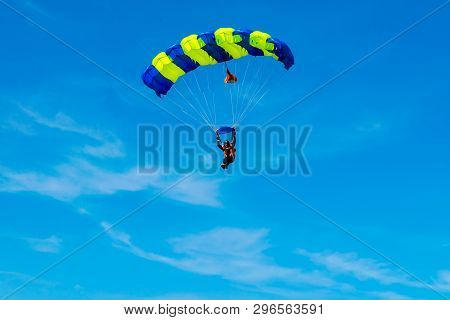Male Skydiver Flies Under The Wing Of The Parachute, Descending And Coming In To Land Closer To The 
