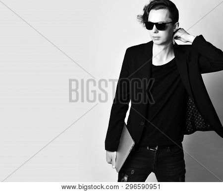 Young Stylish Man In Sunglesses With A Laptop Stands Near Free Text Space With His Elbow On The Edge