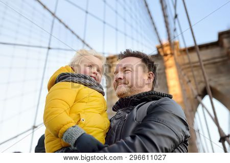 Cute Little Boy And His Father On Brooklyn Bridge With Skyscrapers On Background. Family Travel With