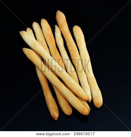 Fresh Golden Breadsticks Top View On Dark Wooden Background. Traditional Italian Grissini. Dry Bread
