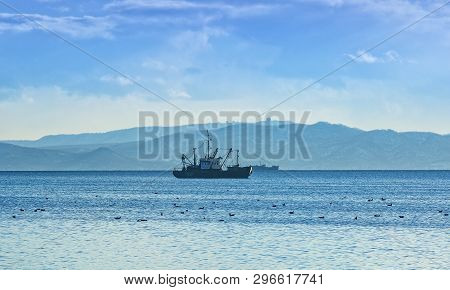 The Fishing Boat In Gray Morning On Pacific Ocean Off The Coast Of The Kamchatka Peninsula