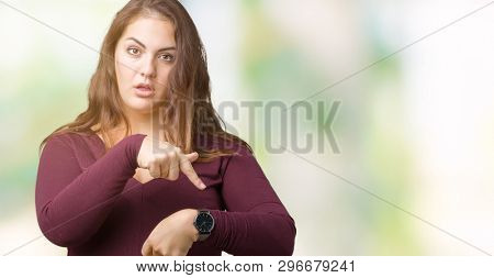 Beautiful and attractive plus size young woman wearing a dress over isolated background In hurry pointing to watch time, impatience, upset and angry for deadline delay