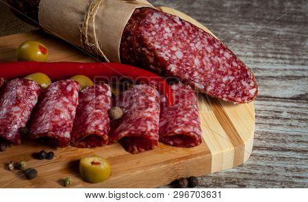 Italian Salami With Olives And Spices On Wooden Background