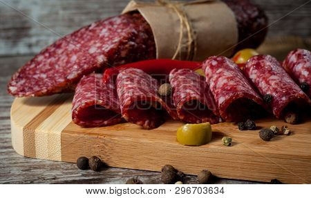 Italian Salami With Olives And Spices On Wooden Background