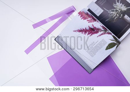 Elegant Flat Lay-out With Purple Floral Packaging And A Book About Astilba (flowers) With Space For 