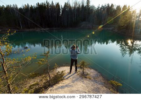 Young Man Take Travel Photos - Beautiful Turquoise Lake In Latvia - Meditirenian Style Colors In Bal