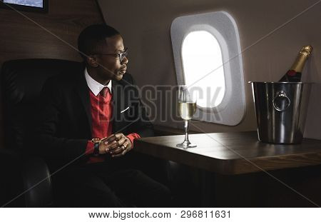 Successful Young Afro American Black Businessman Sitting In The Chair Of His Private Jet