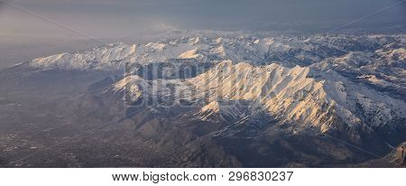 Aerial View From Airplane Of The Wasatch Front Rocky Mountain Range With Snow Capped Peaks In Winter