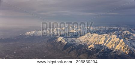 Aerial View From Airplane Of The Wasatch Front Rocky Mountain Range With Snow Capped Peaks In Winter