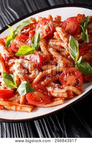 Delicious Italian Pasta Casarecce With Tomato Sauce, Parmesan And Basil Closeup On A Plate. Vertical