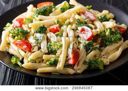 Delicious Italian Pasta Casarecce With Broccoli, Garlic And Tomatoes In A Creamy Sauce Close-up On A