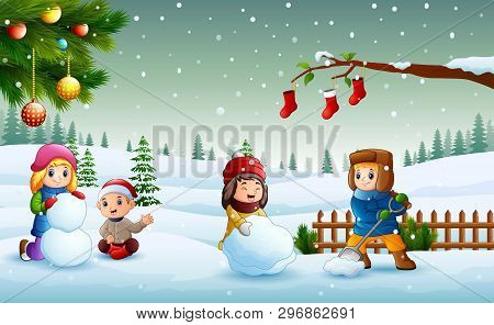 Happy Kids Playing On The Snow And Making A Snowman In Christmas Day