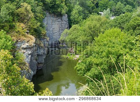 Calm River Flowing In Canyon With Overhanging Cliffs On Bank Among Forest At Summer Day, Top View. B