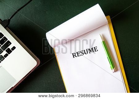 Resume On A Clipboard With Office Table Background. A Hiring Or Employment Concept