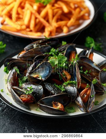 Mussels With White Wine, Garlic, Lemon And Herbs In A Plate, French Fries. Rustick Background. Seafo