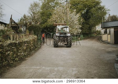 Sarria, Spain - April 6th, 2019: Camino De Santiago Pilgrim Walking With A Backpack Across A Rural P