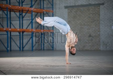 An Athletic Man On Capoeira Training. Standing On One Hand